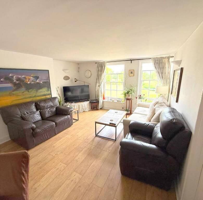 Spacious living room with leather sofas, large windows, and natural light in Wavendon House Drive, M.