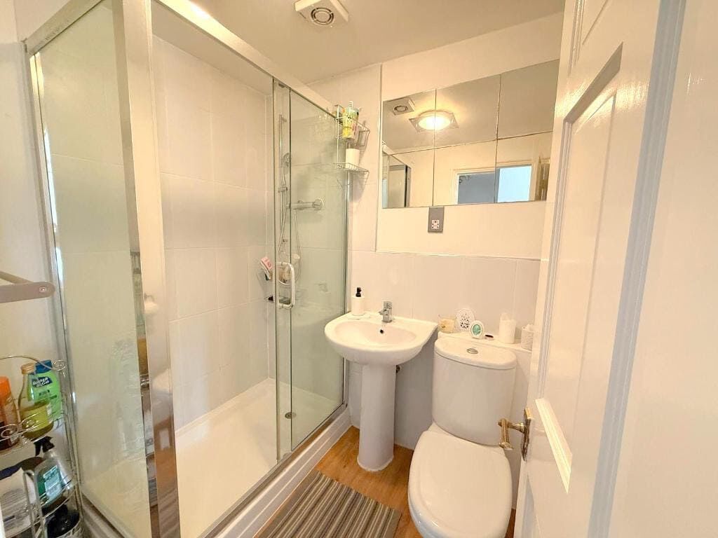 Modern bathroom with shower, sink, and toilet in Milton Keynes apartment. Bathroom with shower, sink, and toilet in a luxury Milton Keynes apartment.
