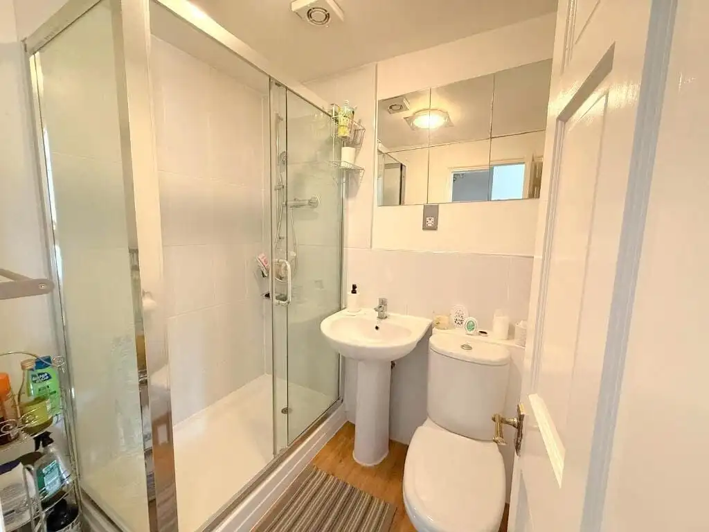 Modern bathroom with shower, sink, and toilet in Milton Keynes apartment. Bathroom with shower, sink, and toilet in a luxury Milton Keynes apartment.