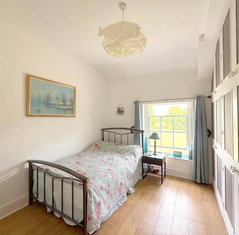 Spacious bedroom with vintage bed frame and natural light in Wavendon House Drive.