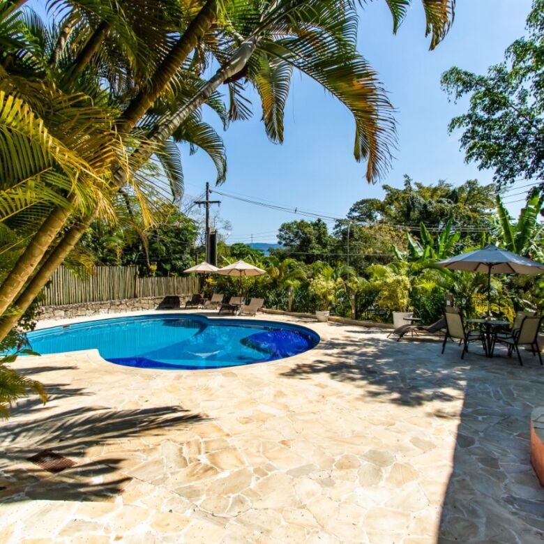 Beautiful outdoor pool area at a boutique hotel in Ilhabela, surrounded by lush tropical greenery.