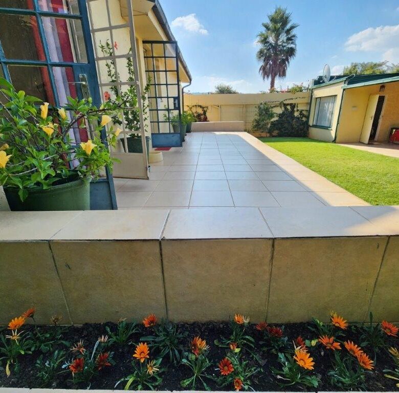 Beautiful 4-bedroom house for sale in Albertville, Johannesburg with a spacious patio and lush garde.