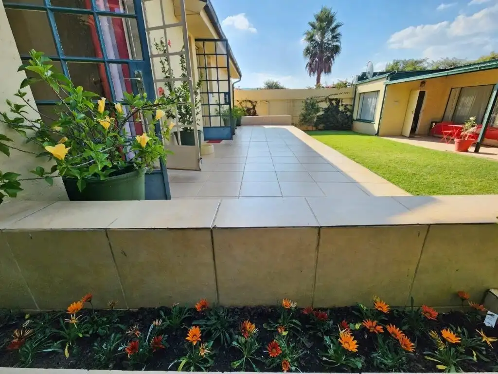 Beautiful 4-bedroom house for sale in Albertville, Johannesburg with a spacious patio and lush garde.