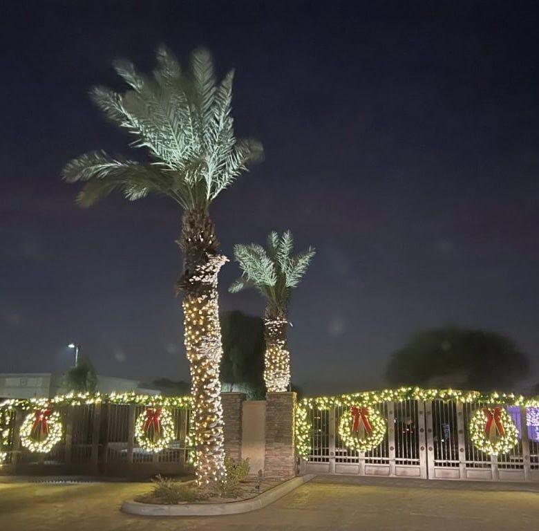 Luxury 4 Bed Villa for Sale in Indio, California with festive holiday lights and palm trees.