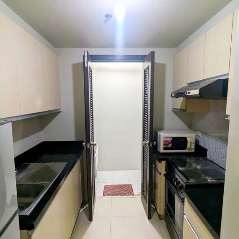 Compact kitchen in Kroma Tower Manila with modern appliances and sleek cabinetry.