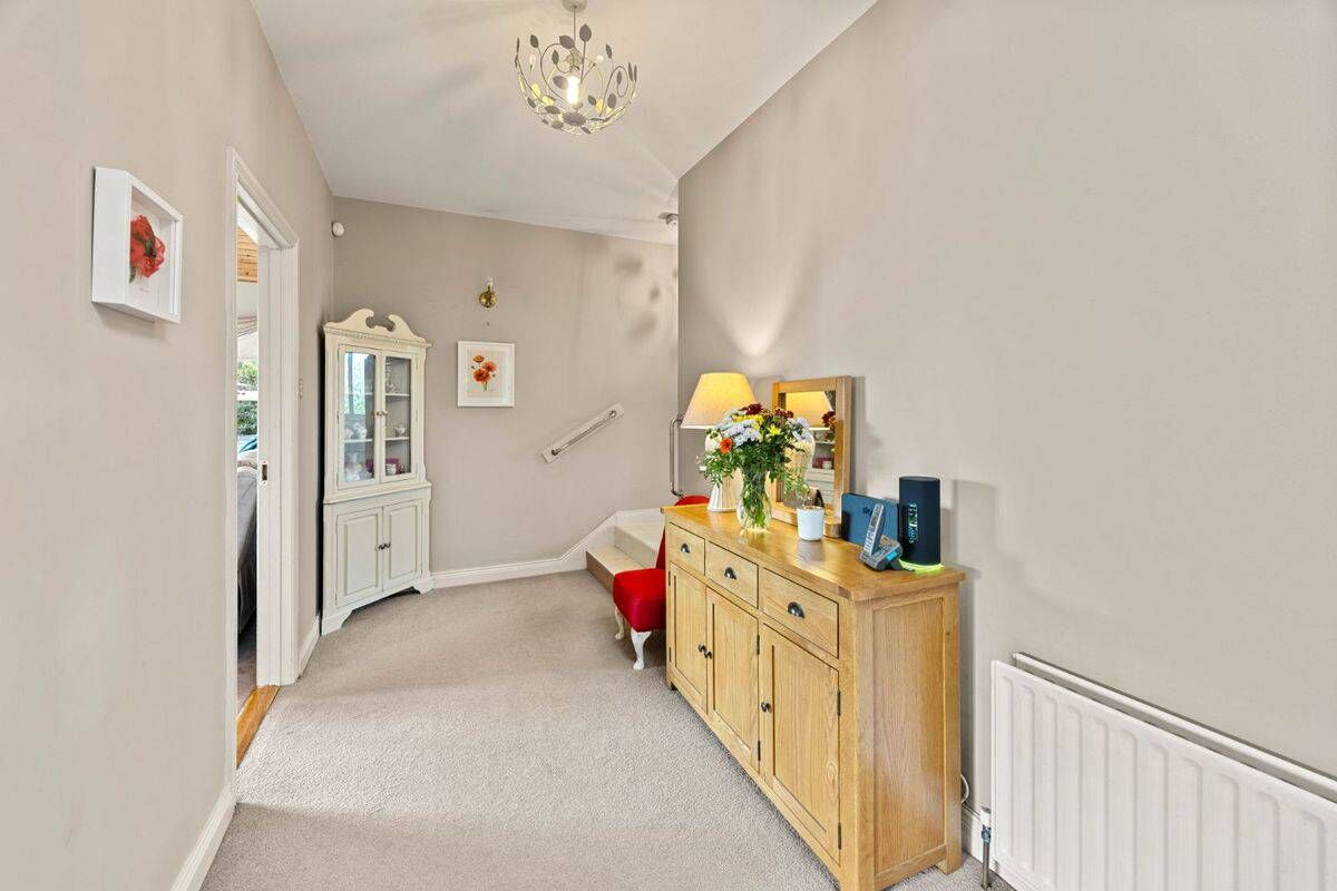 Springhill Lodge Interior Bright hallway with a wooden sideboard and floral decor.