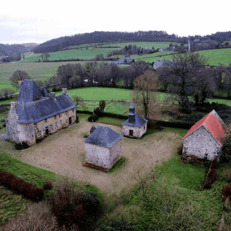 Le Manoir de Dougeru estate in Normandy with historic buildings and lush landscape.