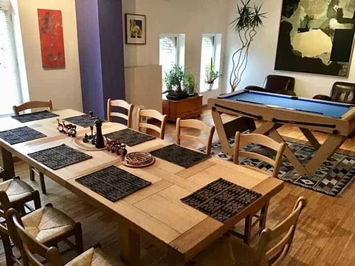 Bright dining room featuring a large table and a pool table for entertainment.