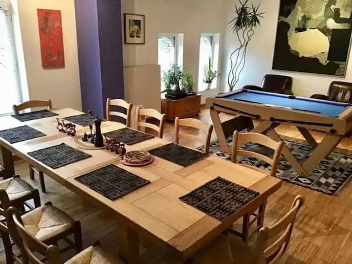 Bright dining room featuring a large table and a pool table for entertainment.