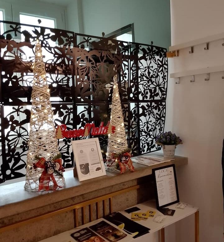 Elegant Christmas decorations with white trees and festive accents in a stylish apartment setting.