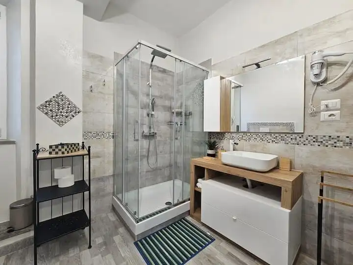 Spacious bathroom with glass shower enclosure and contemporary fixtures.