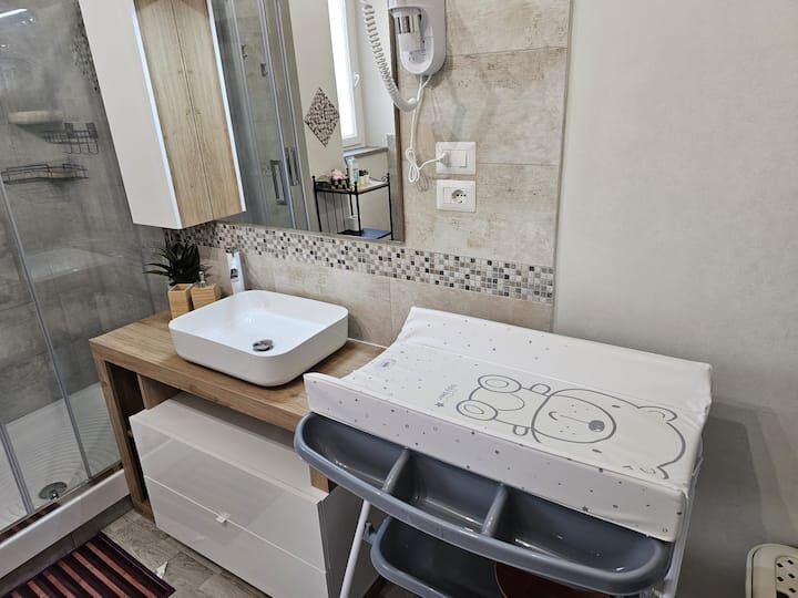 Baby changing station with cute bear design in contemporary bathroom setting.