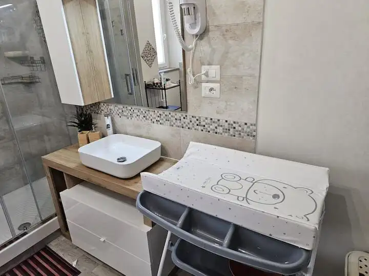 Baby changing station with cute bear design in contemporary bathroom setting.