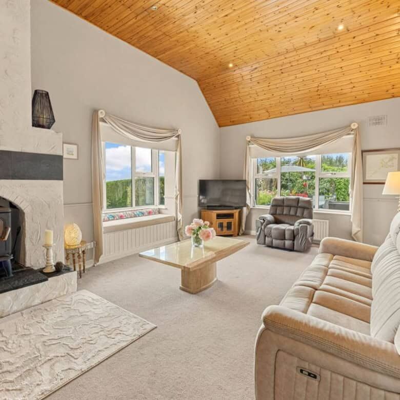 Cozy living room with a fireplace and large windows in Ballycorrigan, Ballina, Co Tipperary.