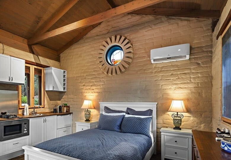 Elegant bedroom with rustic wooden ceiling and modern amenities in Flowerdale Vic.