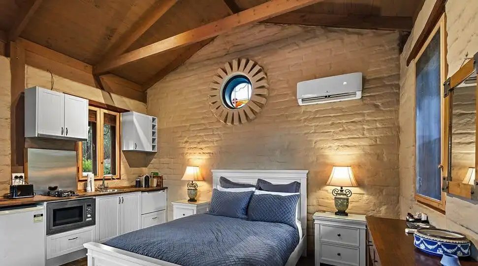 Elegant bedroom with rustic wooden ceiling and modern amenities in Flowerdale Vic.