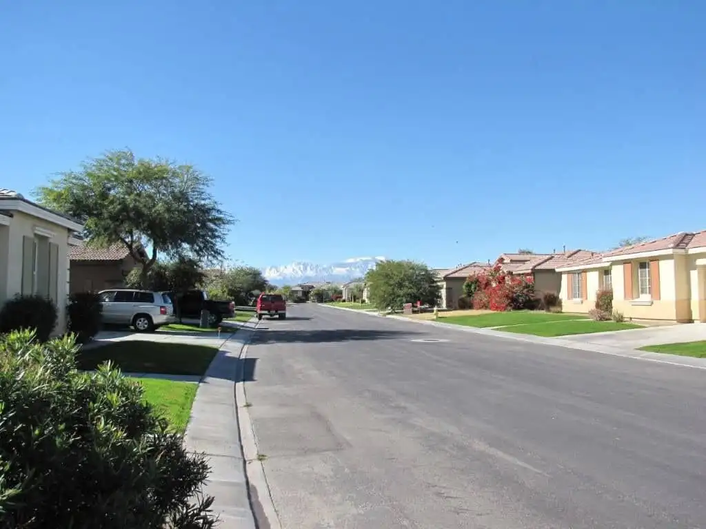 Beautiful residential street in Indio with spacious homes and lush greenery.