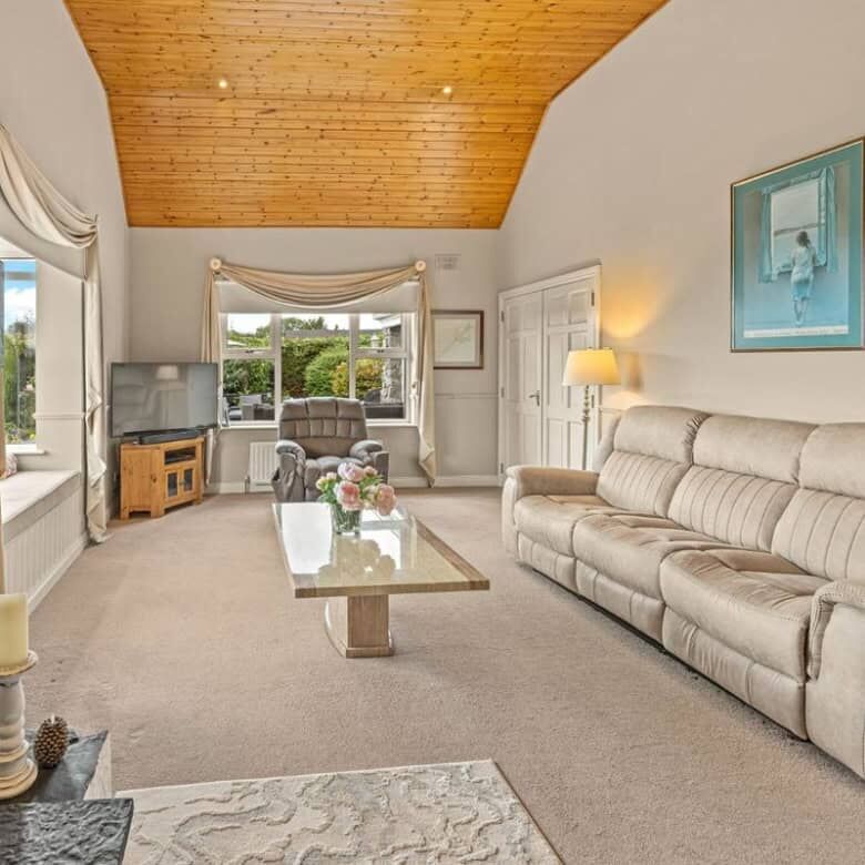 Spacious living room with a fireplace, large windows, and comfortable seating in Ballycorrigan, Ball.