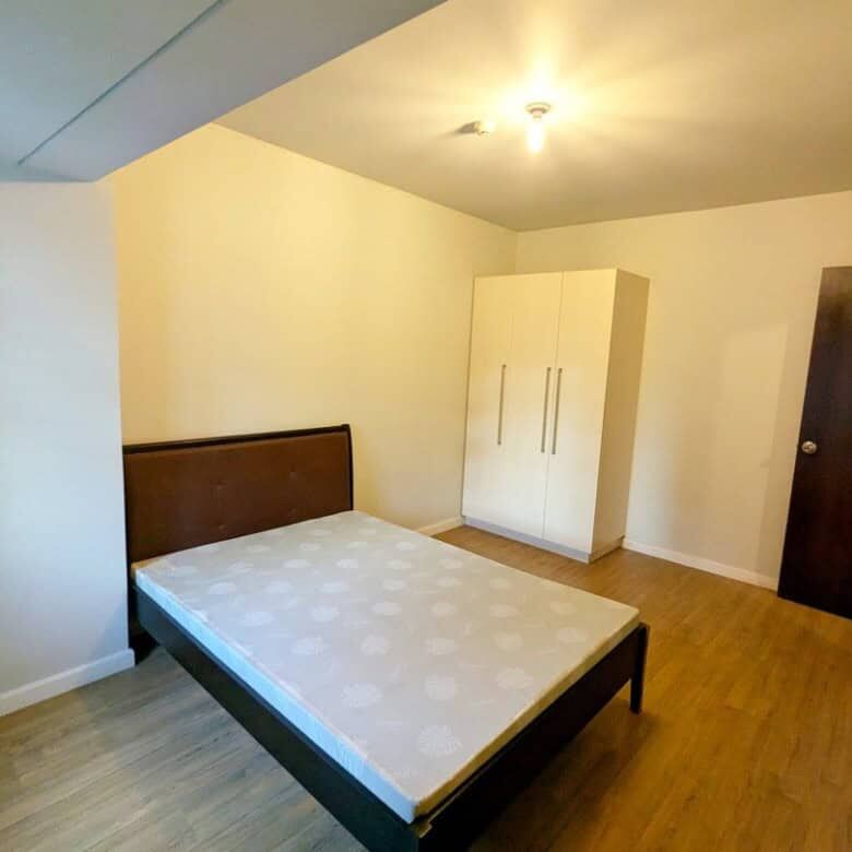Interior view of a 1-bedroom apartment in Kroma Tower Manila, featuring a bed and wardrobe.