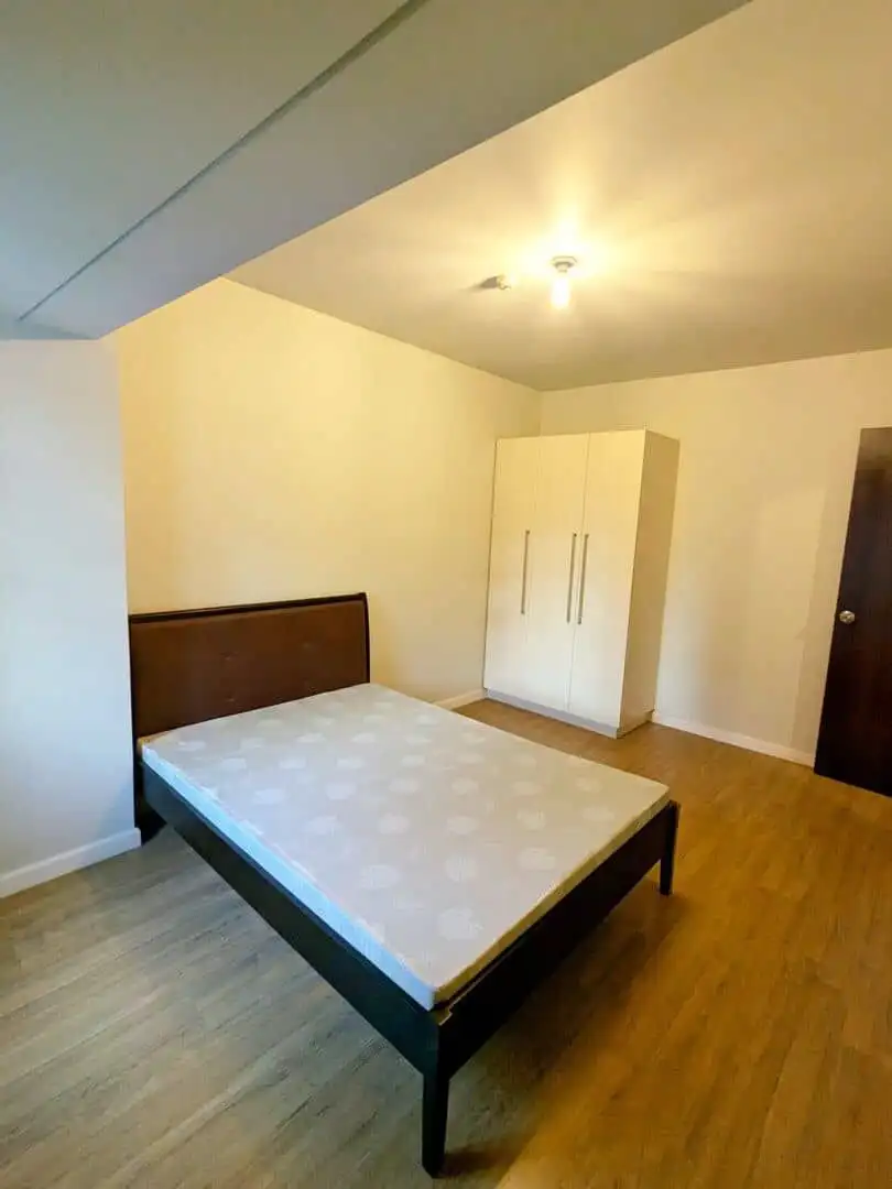 Interior view of a 1-bedroom apartment in Kroma Tower Manila, featuring a bed and wardrobe.