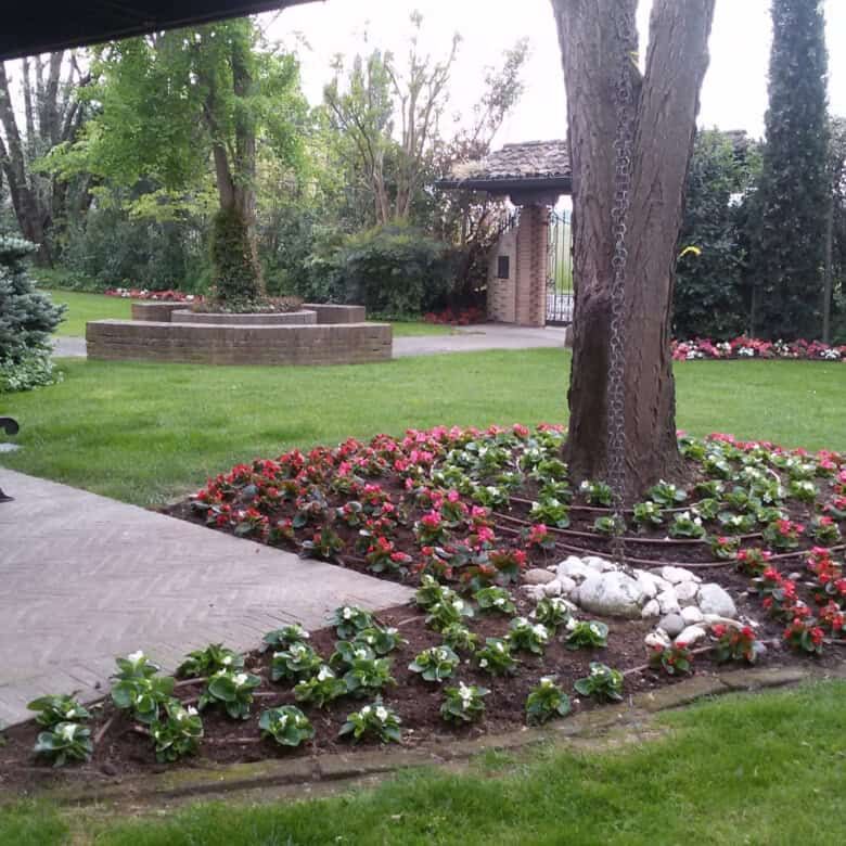 Elegant garden with lush greenery and colorful flowers in Forli estate.