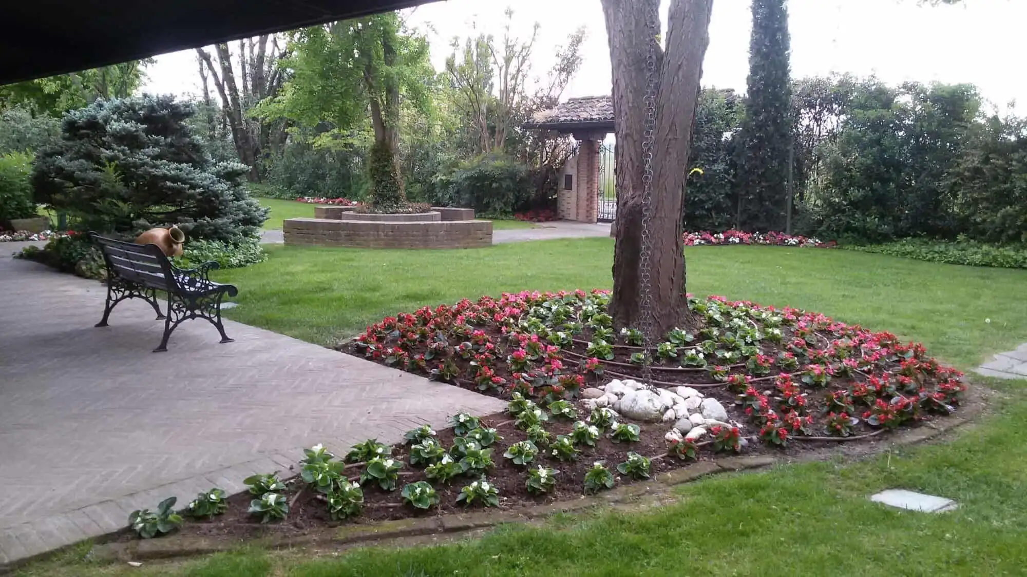 Elegant garden with lush greenery and colorful flowers in Forli estate.