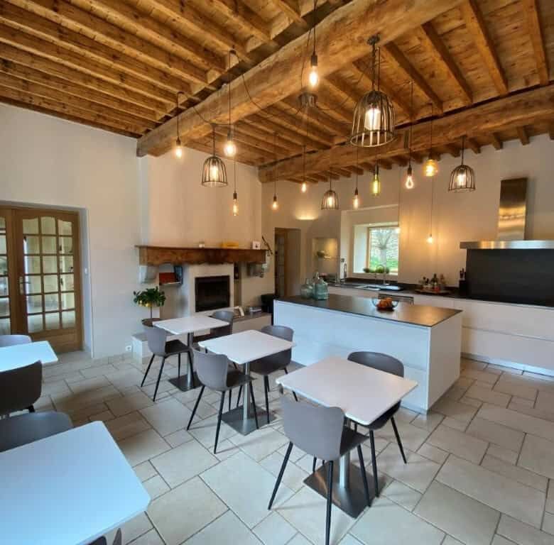 Cozy interior of La Maison du Bonheur Bed and Breakfast in Ausson, featuring rustic wooden ceiling a.