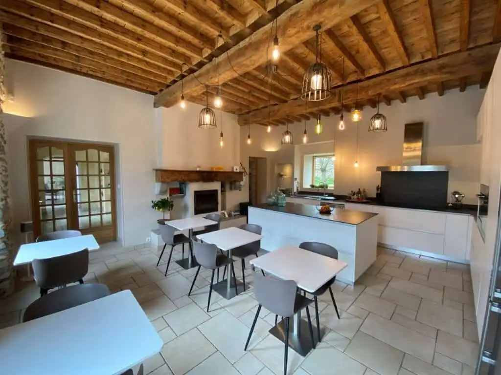 Cozy interior of La Maison du Bonheur Bed and Breakfast in Ausson, featuring rustic wooden ceiling a.