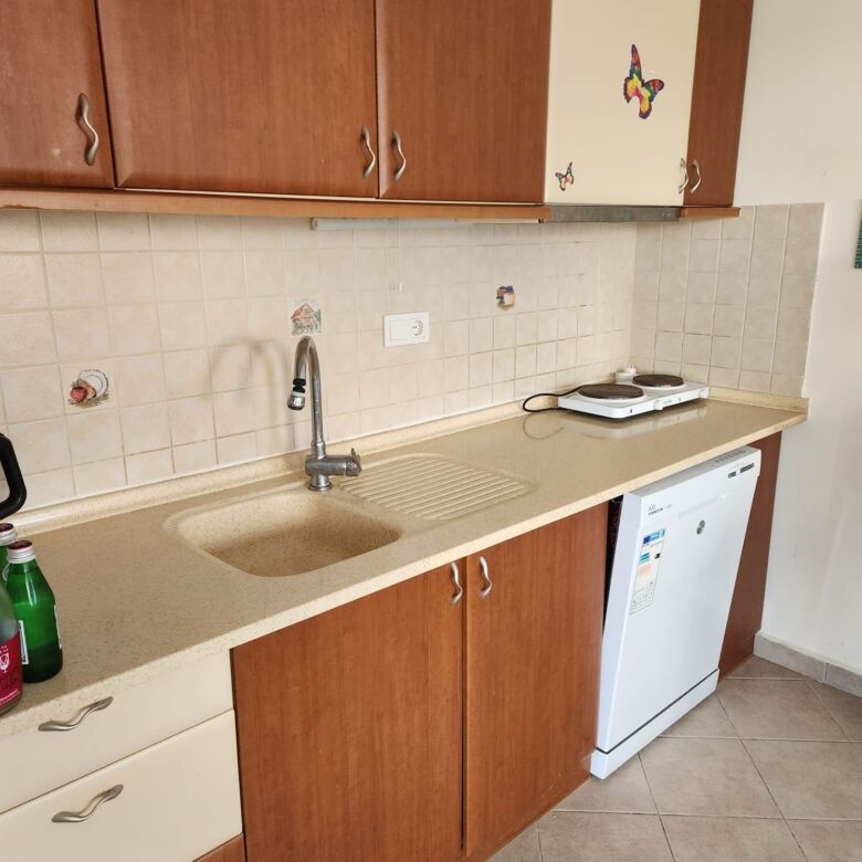 Spacious kitchen with wooden cabinets, sink, and appliances in a luxury villa in Gumusluk.