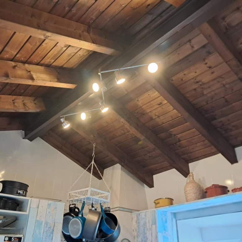 Modern villa kitchen featuring a wooden ceiling and contemporary lighting in Faro Algarve.