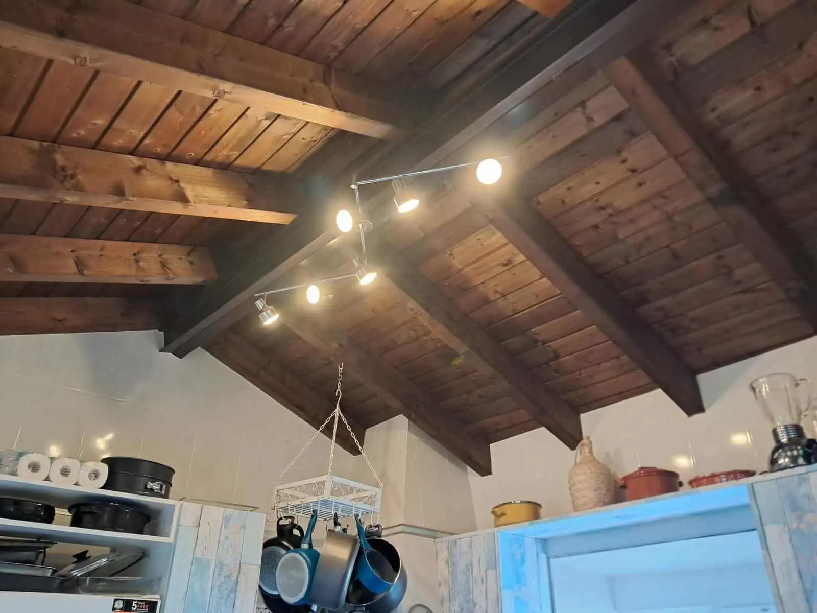 Modern villa kitchen featuring a wooden ceiling and contemporary lighting in Faro Algarve.