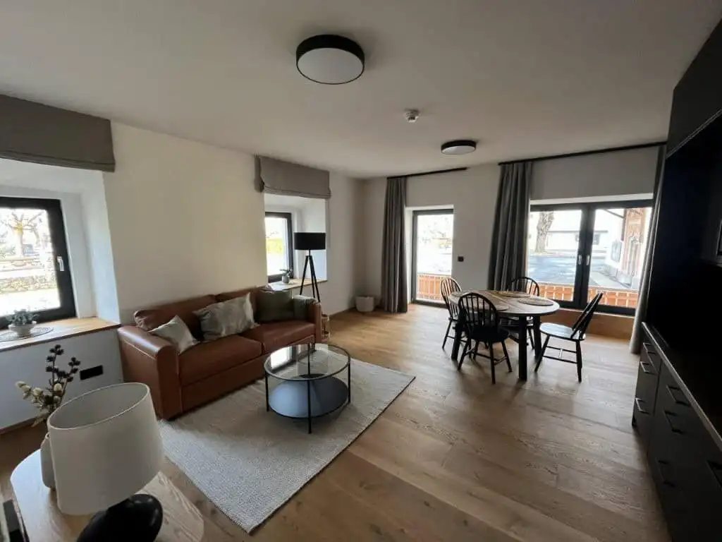 Spacious apartment interior with comfortable seating, dining area, and natural light.