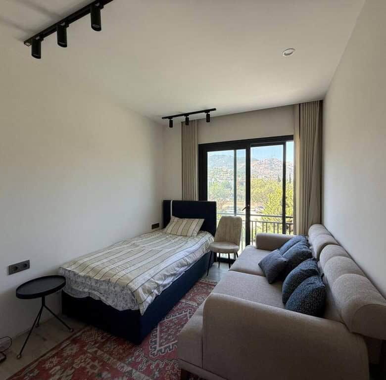 Bright interior of a luxury 2-bedroom apartment in Yalıkavak Bodrum with large window and scenic vie.