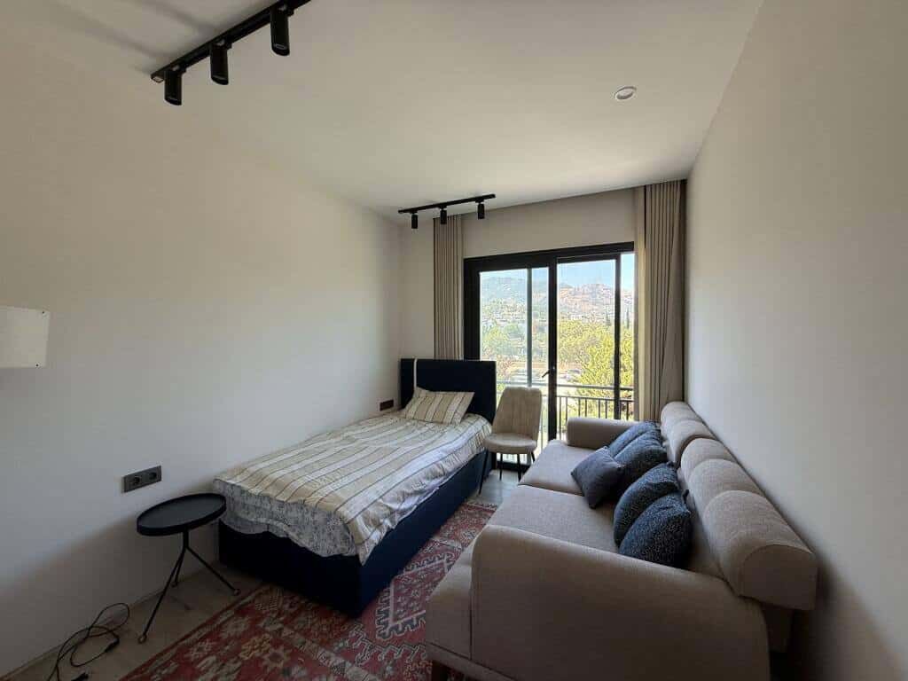 Bright interior of a luxury 2-bedroom apartment in Yalıkavak Bodrum with large window and scenic vie.