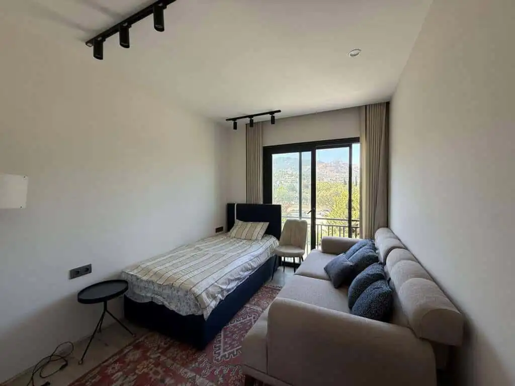 Bright interior of a luxury 2-bedroom apartment in Yalıkavak Bodrum with large window and scenic vie.
