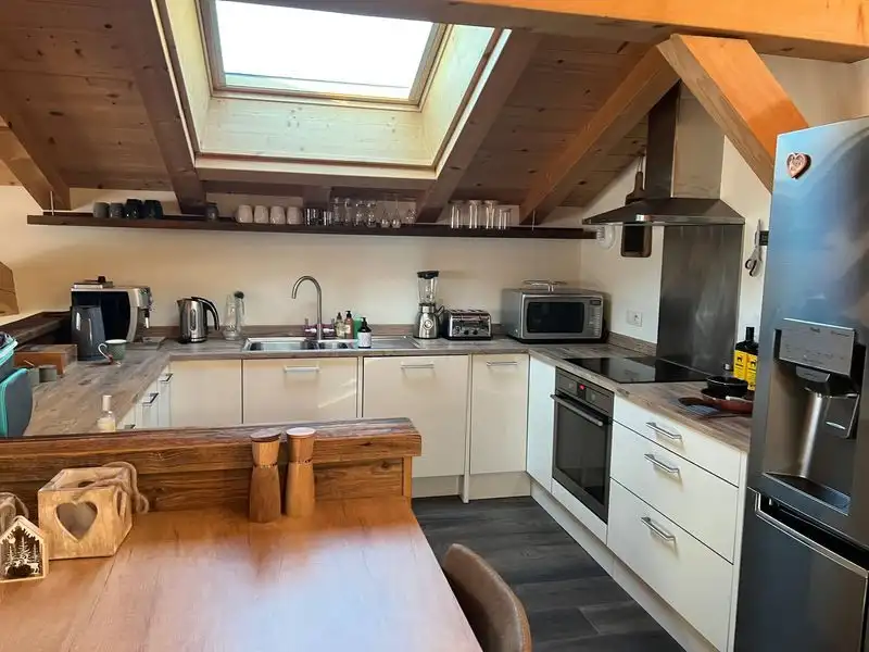 Charming kitchen in a luxury 5-bedroom chalet in Samoens with modern appliances and wooden accents.