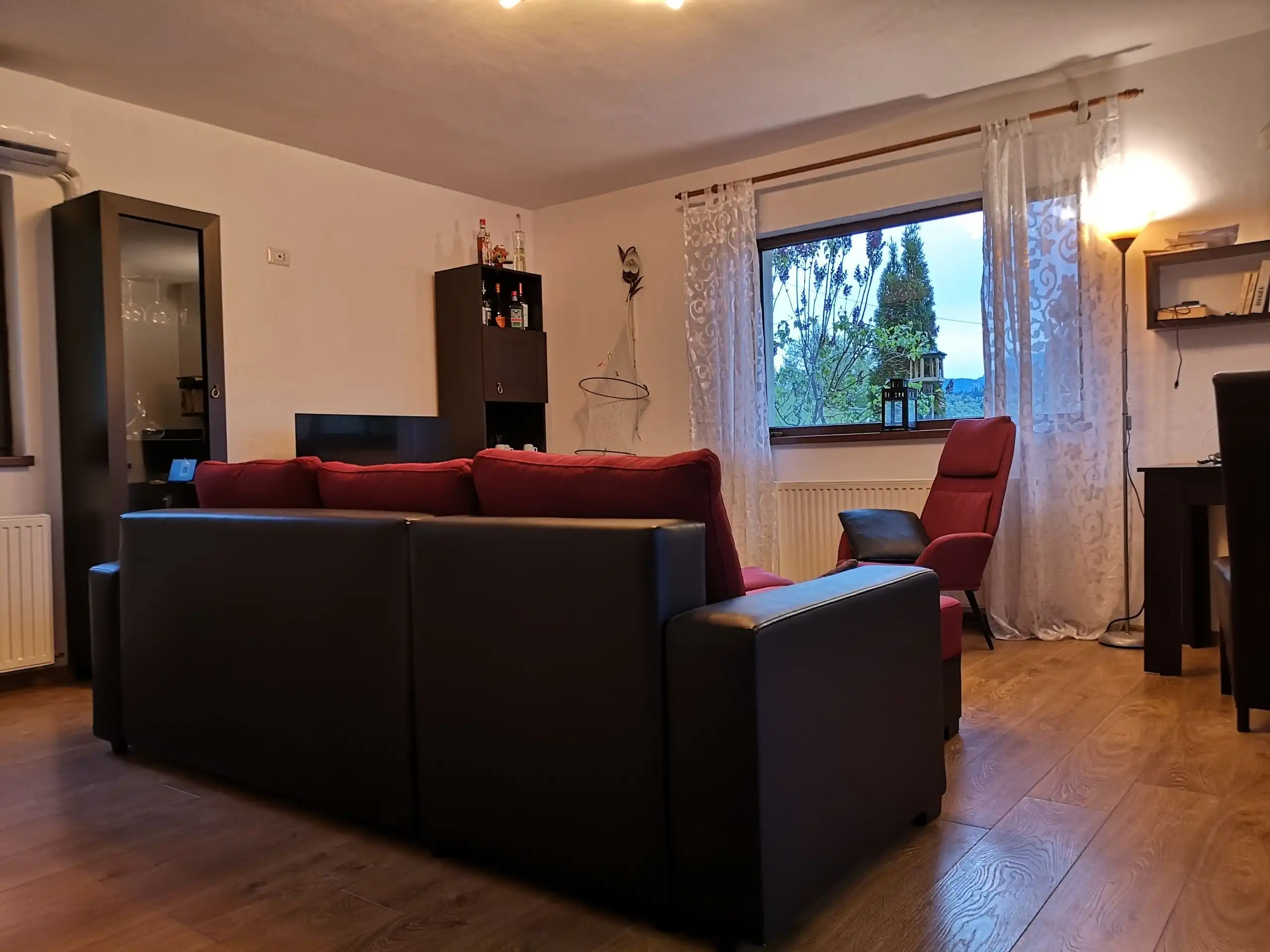 Interior view of a living room with two houses for sale in Bicaz, featuring sofas and a large window.