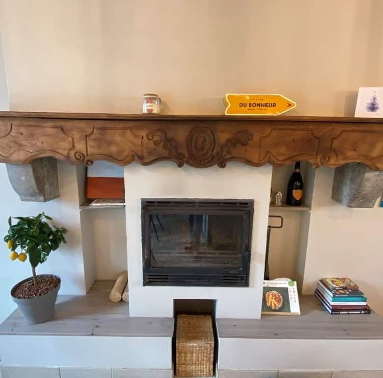 Cozy fireplace with a wooden mantel in a stylish home interior.