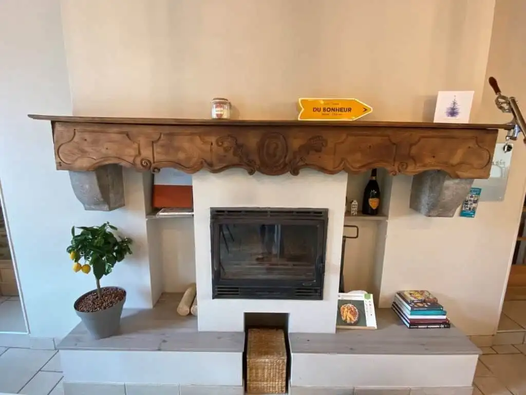 Cozy fireplace with a wooden mantel in a stylish home interior.