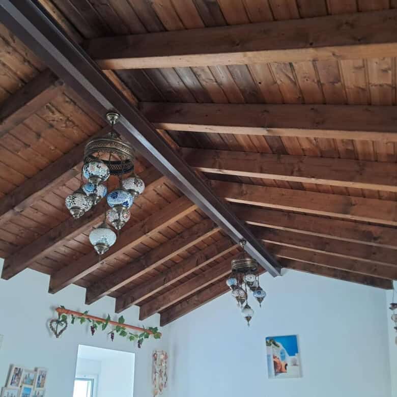 Elegant wooden ceiling with chandeliers in a spacious, well-lit interior.