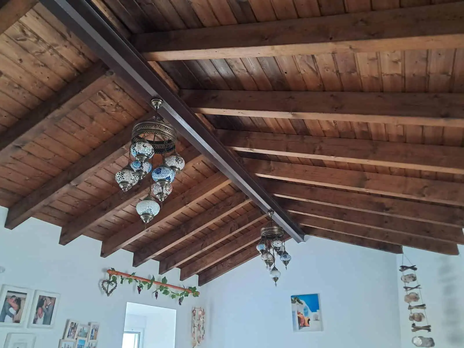 Elegant wooden ceiling with chandeliers in a spacious, well-lit interior.