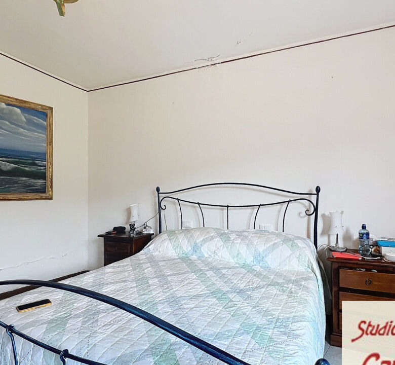 Spacious bedroom in a beautiful Tuscan house with classic iron bed frame and simple decor.