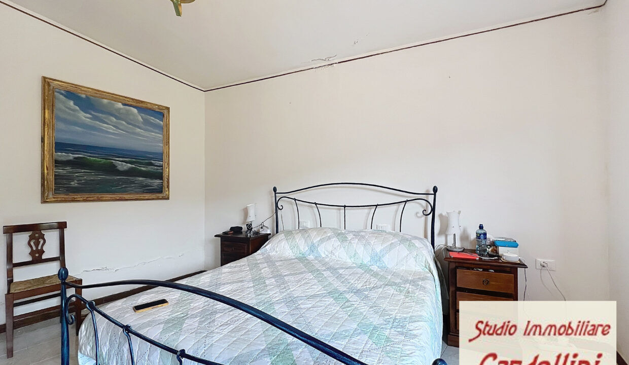 Charming 4-Bed Fivizzano Home Spacious bedroom in a beautiful Tuscan house with classic iron bed frame and simple decor.
