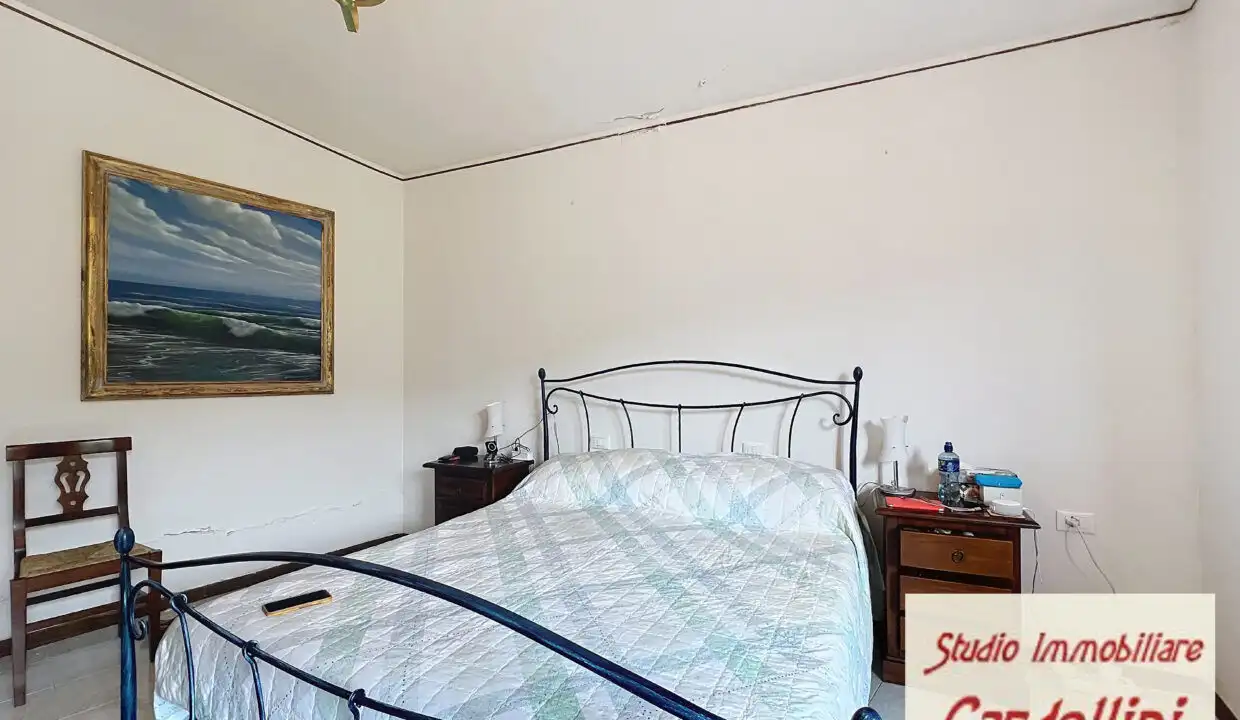 Spacious bedroom in a beautiful Tuscan house with classic iron bed frame and simple decor.