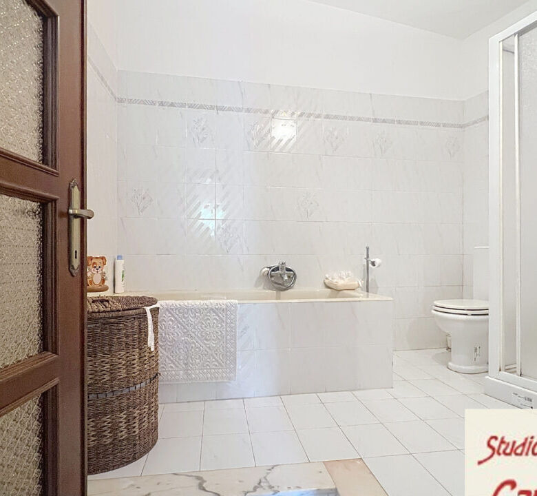 Bathroom with bathtub, shower, and toilet in a spacious, bright room.