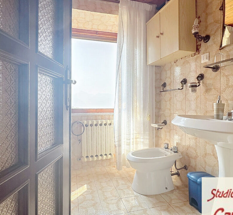 Bright bathroom with vintage decor in Fivizzano Tuscany, featuring a classic sink, toilet, and natur.