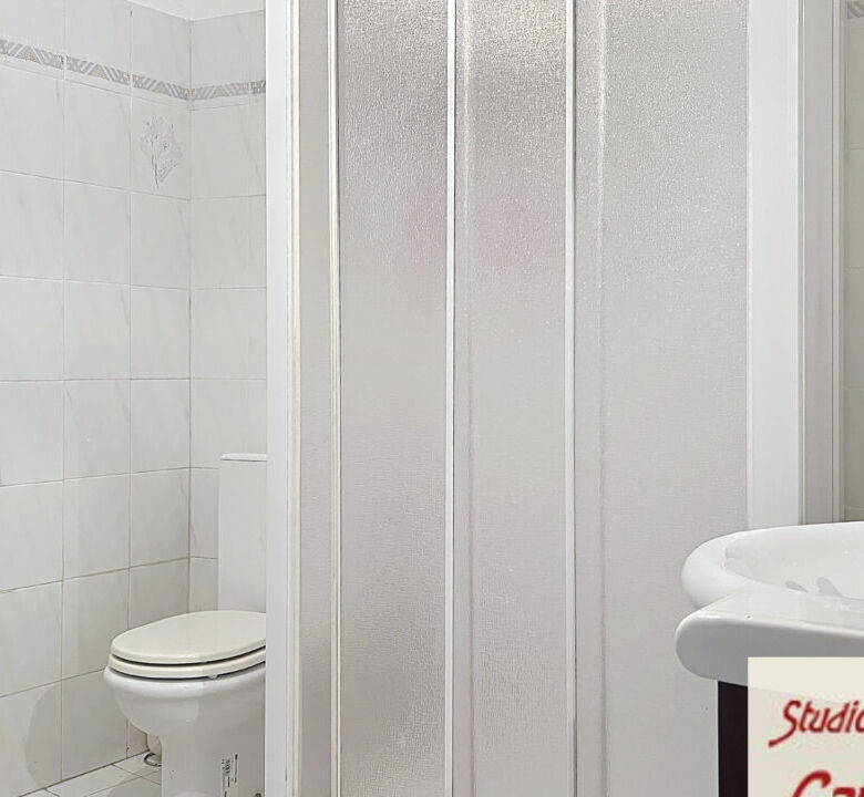 Bright bathroom with shower, toilet, and sink in a charming Tuscan home.