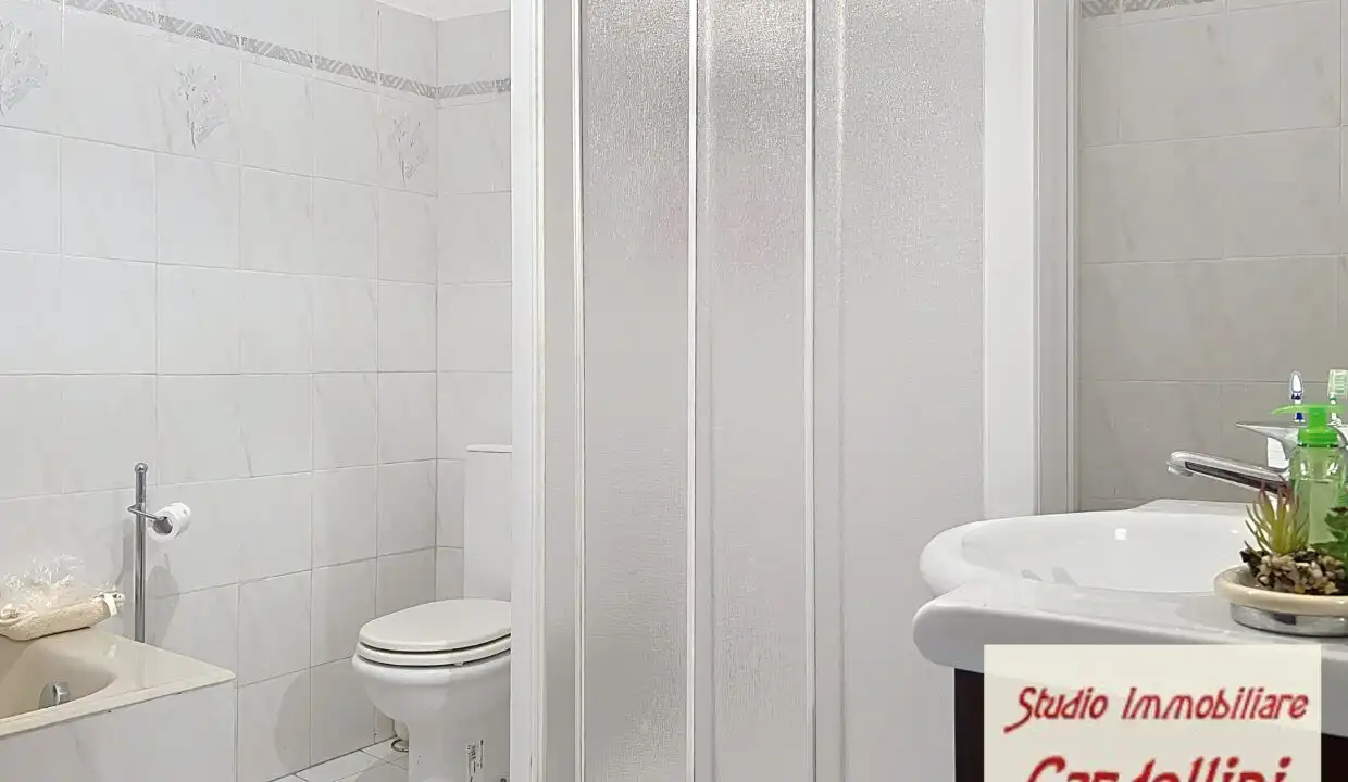 Bright bathroom with shower, toilet, and sink in a charming Tuscan home.
