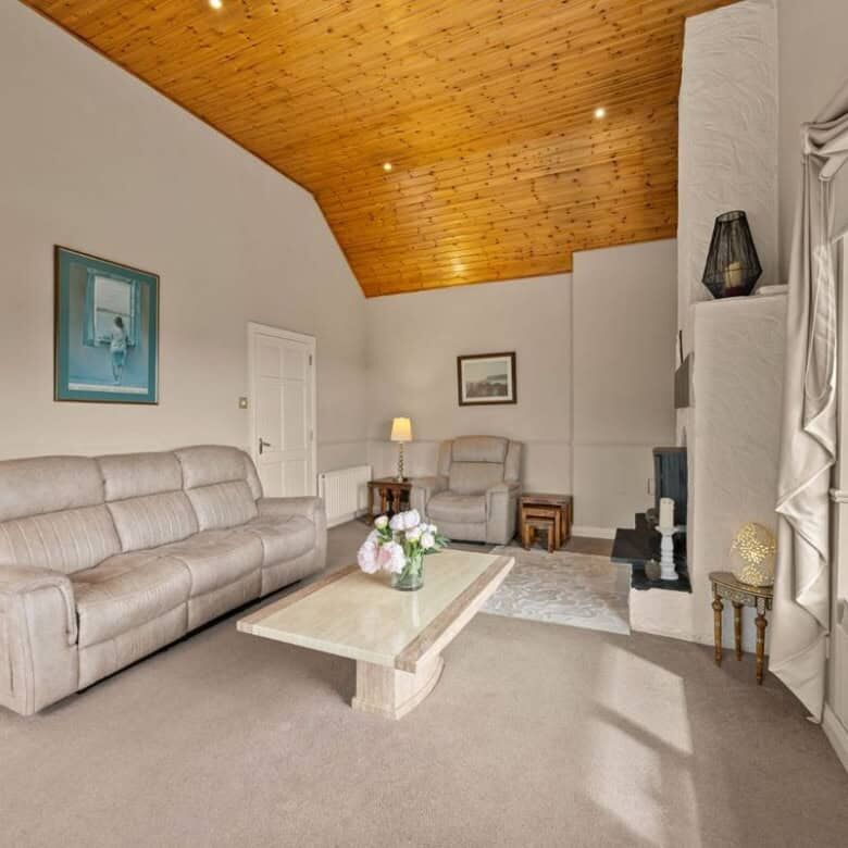Bright living room with comfortable sofas and a cozy fireplace in Ballycorrigan, Ballina.