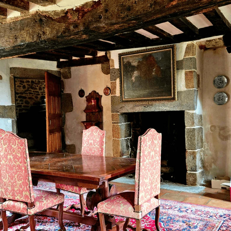 Charming interior of a historic manor with exposed wooden beams and antique furnishings.